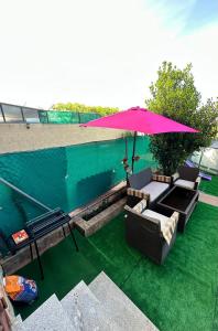 a patio with an umbrella and a table and chairs at Casa rural con jardín y piscina in Val de Santo Domingo