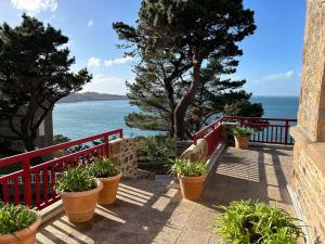 d'un balcon avec des plantes en pot et une vue sur l'océan. dans l'établissement Appartement Perros-Guirec, 7 pièces, 8 personnes - FR-1-542-63, à Perros-Guirec
