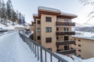 un edificio de apartamentos con nieve en el suelo en Chesa Sonnalpine B - St. Moritz en St. Moritz
