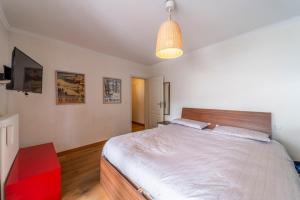 1 dormitorio con 1 cama grande y luz colgante en Chesa Sonnalpine B - St. Moritz en St. Moritz