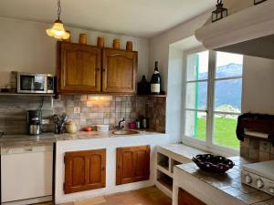 a kitchen with wooden cabinets and a sink and a window at Maison Rencurel, 8 pièces, 15 personnes - FR-1-548-44 in Rencurel