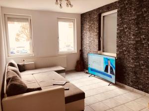 a living room with a couch and a flat screen tv at quiet apartment in middle of city centre in Tuttlingen