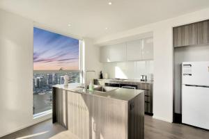 uma cozinha com uma grande janela com vista para a cidade em Stunning 3B2B1C high-rise with a water frontage 1 em Melbourne