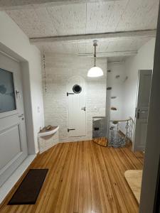 a large room with a wooden floor and a white door at Porto de calma in Naousa