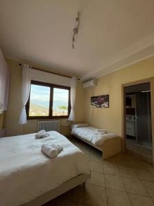 een slaapkamer met 2 bedden en een groot raam bij B&B Garzola in Ossuccio