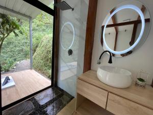 ein Bad mit einem Waschbecken und einem Spiegel in der Unterkunft Safari Lodge Ecuador in Bucay