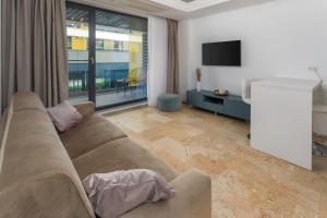 a living room with a couch and a flat screen tv at Astria Monaco - Complex Novum in Olimp