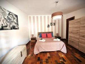 a bedroom with a bed with red and blue pillows at Arborea Studio Apartment in Porto Torres