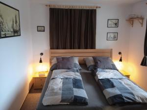 two beds in a bedroom with two lamps at Jitřenka chata s cateringem in Trojanovice
