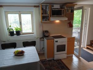 a kitchen with a table with a bowl of fruit on it at Jitřenka chata s cateringem in Trojanovice