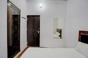 sypialnia z łóżkiem i drewnianymi drzwiami w obiekcie OYO Grand Hotel w mieście Meerut