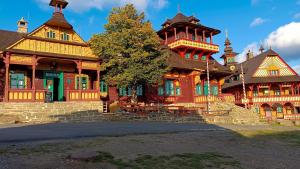 a large wooden house with a tree in front of it at Jitřenka chata s cateringem in Trojanovice