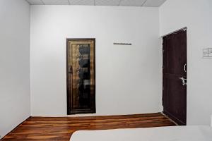 Pokój z drzwiami i zdjęciem na ścianie w obiekcie OYO Grand Hotel w mieście Meerut