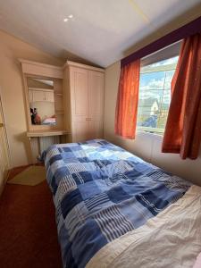 1 dormitorio con cama y ventana en Seaside Chalet en Quilty