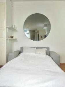 a bedroom with a large white bed and a mirror at City Center Residence - 64 m2 St Eriksplan in Stockholm