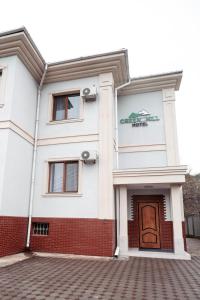 a white building with a brown door at Green Hill in Almaty