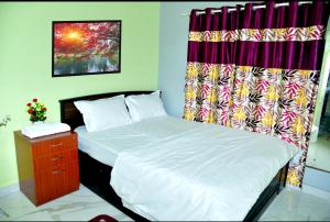 ein Schlafzimmer mit 2 Betten, einem Vorhang und einer Kommode in der Unterkunft Royal Guest House in Chikmagalur