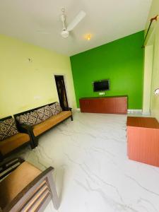 a room with a green wall and two beds in it at Royal Guest House in Chikmagalūr