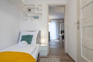 1 dormitorio con 1 cama con manta amarilla en Karkonosky Apartamenty - Majówka, en Szklarska Poręba