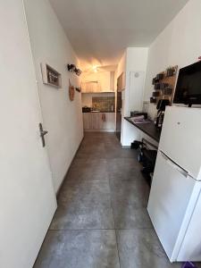 a hallway of a kitchen with a refrigerator at T2 centre Ville Proche des pistes in Briançon