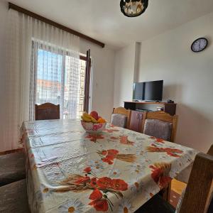 a dining room table with a bowl of fruit on it at Apartman Agava in Njivice