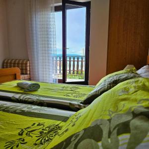 a bedroom with two twin beds and a window at Apartman Agava in Njivice