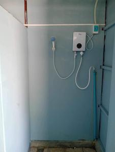 ein Badezimmer mit einer blauen Wand und einem Wasserschlauch in der Unterkunft JIJI KOH RONG in Phumĭ Kâoh Rŏng