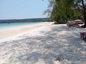 two picnic tables on a beach near the water at JIJI KOH RONG in Kaôh Rŭng (3)