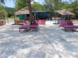 un grupo de sillas y sombrillas púrpuras en la playa en JIJI KOH RONG, en Kaôh Rŭng (3)