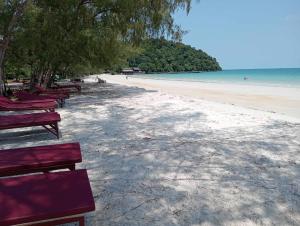 a row of red benches on a beach at JIJI KOH RONG in Kaôh Rŭng (3)