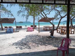 un grupo de mesas y sillas en la playa en JIJI KOH RONG en Kaôh Rŭng (3)