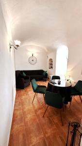 sala de estar con mesa, sillas y sofá en Troglorent - Maison Troglodyte, en Terque