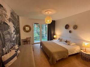 een slaapkamer met een bed en een groot raam bij Le Manoir d'Alexandre in Silfiac
