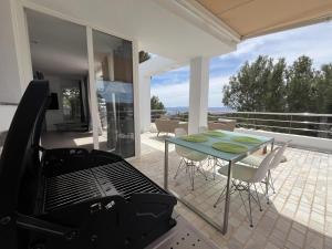 um pátio com comodidades para churrascos, uma mesa e cadeiras em 2b room house with sea view hidromassage and bbq em Talamanca