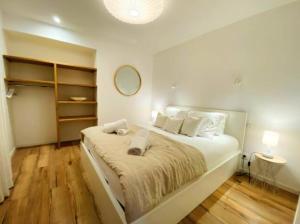 a white bedroom with a large bed with white pillows at Le Petit Rousseau - Maison Climatisé - Classé 4 ETOILES in Hurigny