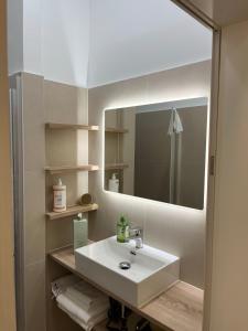 uma casa de banho com um lavatório branco e um espelho. em Urban Citytrip Flat - 15 min to Center em Viena