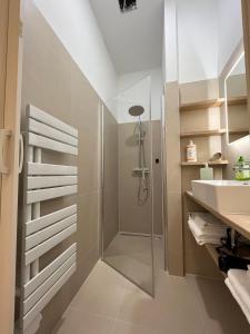 uma casa de banho com um chuveiro e um lavatório. em Urban Citytrip Flat - 15 min to Center em Viena