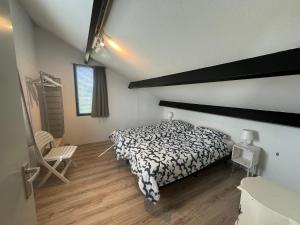 a bedroom with a bed with a black and white comforter at Tesselhoes in De Cocksdorp