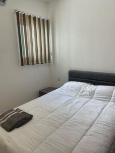 Cama blanca en habitación con ventana en Three bedroom penthouse (Privilege Suite), en San Ġwann