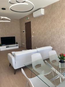 sala de estar con sofá blanco y mesa de cristal en Three bedroom penthouse (Privilege Suite), en San Ġwann