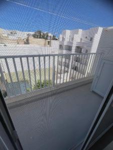 un balcón con una valla blanca y un edificio en Three bedroom penthouse (Privilege Suite), en San Ġwann