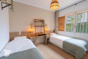 a bedroom with two beds and a desk and a window at Apartamento Margarita in Aduanas