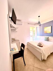 1 dormitorio con 1 cama, escritorio y TV en Light Blue, en Tropea