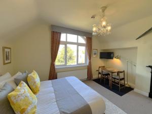 a bedroom with a bed and a window and a table at Melbury Rooms & Studios in Exeter