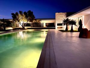 - une piscine au milieu d'une maison la nuit dans l'établissement Villa Nausikaa Essaouira, Villa d'architecte luxe avec piscine, à Essaouira