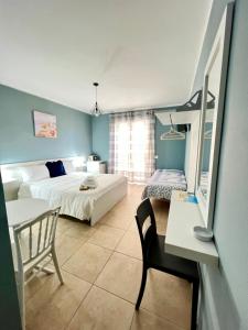 1 dormitorio con 2 camas, mesa y silla en Light Blue en Tropea