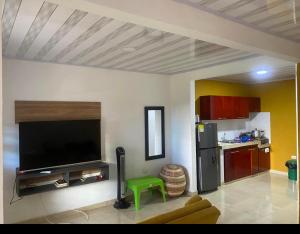 a living room with a flat screen tv and a kitchen at Casa Murillo in San Antero