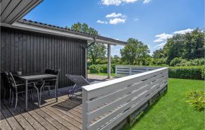 a wooden deck with a table and chairs on it at Holiday Home Brombærvænget Hejls I in Hejls +20 photos