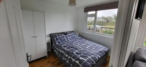 Un dormitorio pequeño con una cama y una ventana. en 2 The Park, en Bude