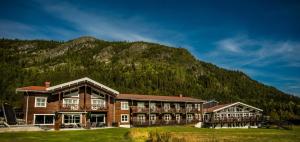 a large building with a mountain in the background at Eriksgårdens Fjällhotell in Funäsdalen